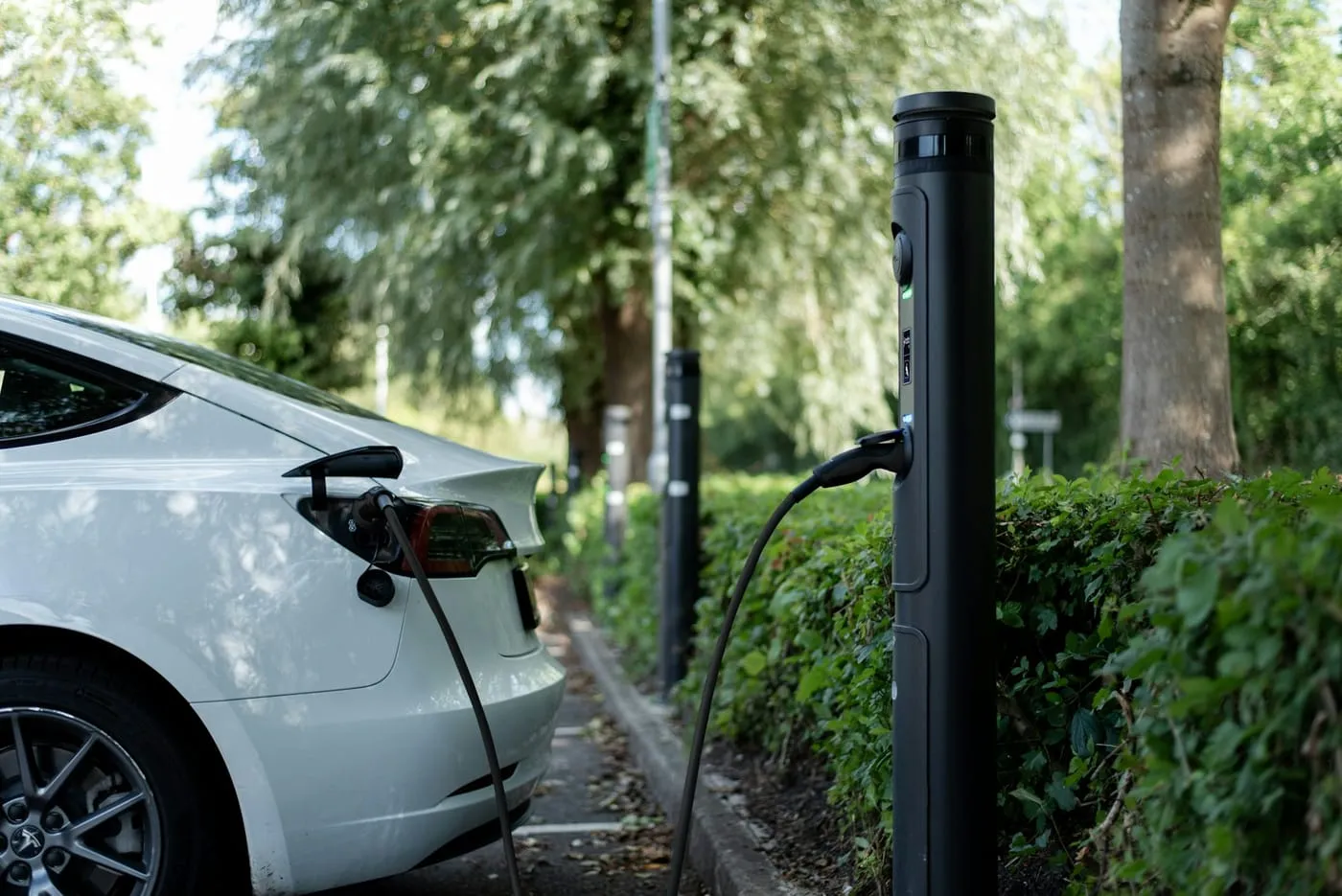 An electric car charging at a curbside station
