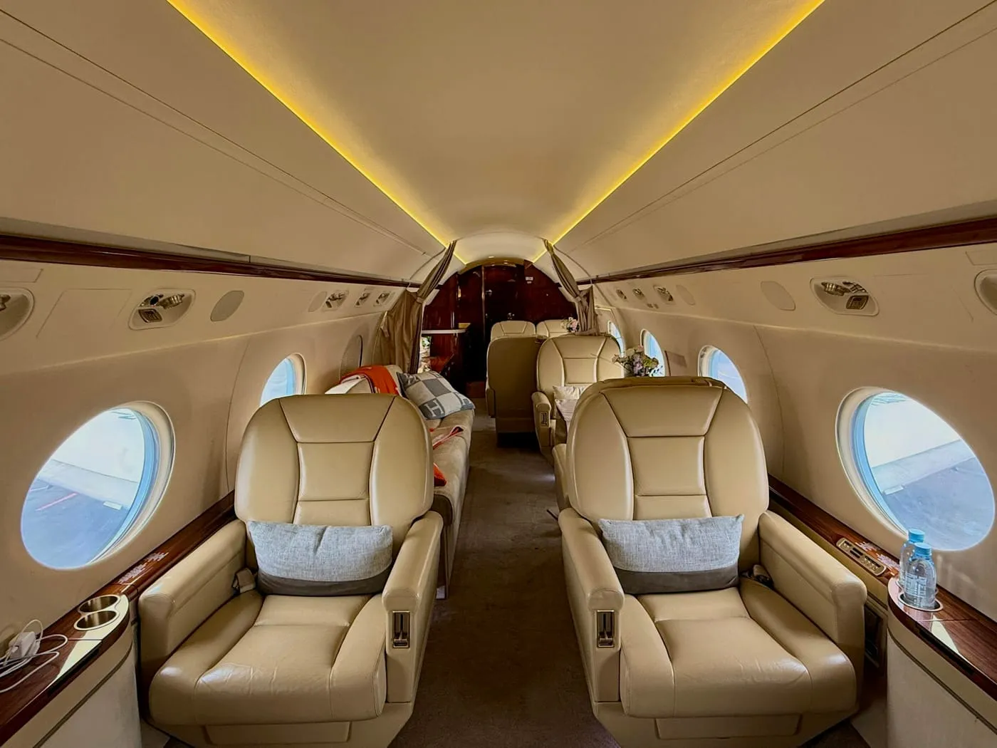 The cabin of a private jet with warm lighting